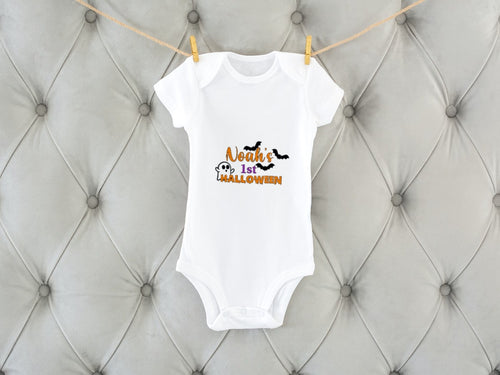 white baby vest with personalised name in orange and the words 