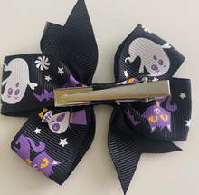 Load image into Gallery viewer, girls halloween hair clip bow. a pattern of ghosts, cats and skeletons on a black bow
