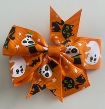 Load image into Gallery viewer, girls halloween hair clip bow. a pattern of ghosts, cats and skeletons on a orange bow
