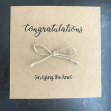 Load image into Gallery viewer, Brown kraft card size 6&quot;x6&quot;. Congratulations is printed along the top in black. With a bow tied from Jute string in the middle and &quot;on tying the knot&quot; underneath
